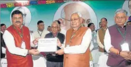  ?? SANTOSH KUMAR/HT ?? CM Nitish Kumar hands certificat­e of election to Umesh Kushwaha at a party programme in Patna on Sunday in the presence of national party president Lalan Singh.