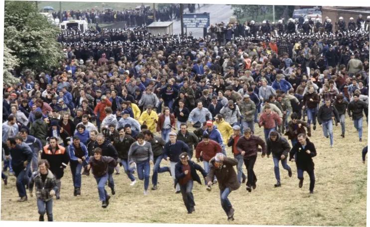  ?? ?? Charge: Pickets sprint up a hill at Orgreave while (inset) a mounted police officer brandishes his baton. The violent scenes of June 18 1984 shocked the nation