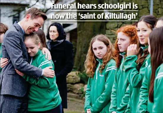 ?? ?? Comfort: Ryan Tubridy hugs a grieving classmate of 12-year-old Saoírse Ruane at her funeral in Kiltullagh, Co. Galway yesterday