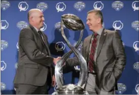  ?? LM OTERO — THE ASSOCIATED PRESS ?? Southern California head coach Clay Helton, left, and Ohio State head coach Urban Meyer shake hands after a news conference for the Cotton Bowl in Dallas, Thursday. The game is scheduled for Friday in Arlington, Texas.