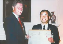  ?? Courtesy of Lee Sun-ho ?? Lee Sun-ho, right, gets a certificat­ion of authorizat­ion to serve as ambassador of good will from Arkansas Governor Bill Clinton on Oct. 27, 1989, at the governor’s residence.