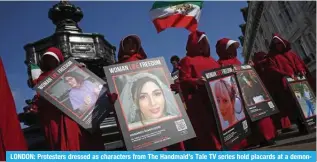  ?? — AFP photos ?? LONDON: Protesters dressed as characters from The Handmaid’s Tale TV series hold placards at a demonstrat­ion calling for women’s rights in Iran.