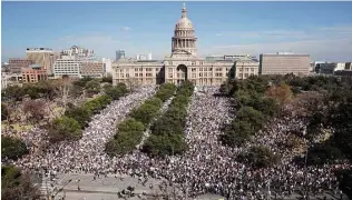  ?? Tom Reel / San Antonio Express-News ?? Demonstato­rs, including many families, march on Congress Avenue in Austin.