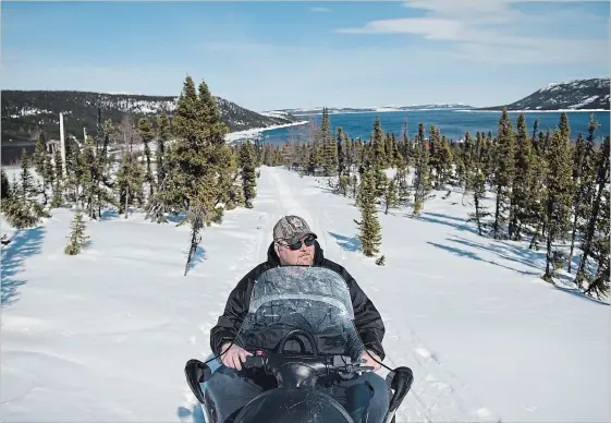  ?? DARREN CALABRESE SPECIAL TO THE WATERLOO REGION RECORD ?? Charlie Flowers, an Inuit hunter and trapper, sits on his snowmobile in Rigolet, in Newfoundla­nd and Labrador. His world is warming and “it’s kind of scary,” he says.