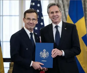  ?? Andrew Caballero-Reynolds/AFP via Getty Images ?? Secretary of State Antony Blinken receives the NATO ratificati­on documents from Swedish Prime Minister Ulf Kristersso­n on Thursday during a ceremony at the State Department in Washington, as Sweden formally joins the North Atlantic alliance.