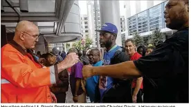  ??  ?? Houston police Lt. Parris Ponton fist-bumps with Charles Davis, a Harvey evacuee, moments after the two engaged in a tense disagreeme­nt at the entrance to the Brown Convention Center in Houston. “We are not turning anyone away,” the city’s mayor said.