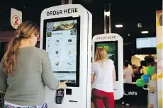  ?? PAUL THOMAS/BLOOMBERG FILES ?? Customers order food inside a McDonald’s restaurant in Manchester, England. Some McDonald’s staff say the revamped operation has increased the workload without adequate staffing.