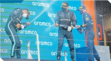  ?? / FOTO: AFP ?? Lewis Hamilton (izq.) festeja en el podio, junto a su coequipero Valtteri Bottas y Max Verstappen.