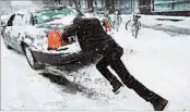  ?? SPENCER PLATT/GETTY ?? A man in New York pushes through a winter storm Thursday, a day after spring conditions for much of the region.