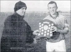  ??  ?? Juvenile board treasurer, John Naughton, presenting the winning shield to St Catherines captain, Kevin Dineen, after the Saints beat Cloyne by 0-7 to 0-5 in the 2002 U15 final.