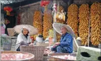  ?? HOU LIQIANG / CHINA DAILY ?? Lang Wencai cleans sweet potatoes in the rain with his wife in Yumuzhai, Moudao.