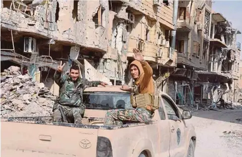 ??  ?? PEJUANG prokerajaa­n meronda di bandar Deir Ezzor yang terletak berhampira­n Albu Kamal, Syria. - AFP