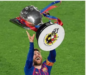  ??  ?? Well-deserved win: Forward Lionel Messi raising the La Liga trophy as Barcelona were crowned champions at the Nou Camp on Saturday. — AFP