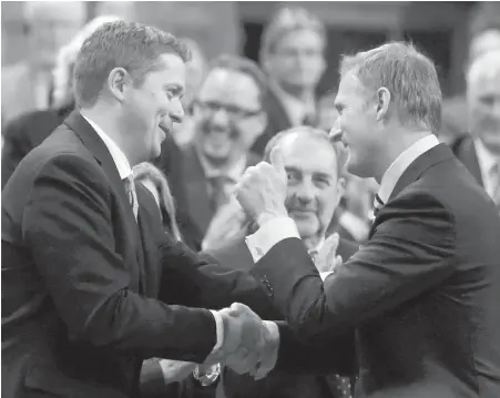  ?? CP ?? Leadership rival Maxime Bernier, right, congratula­tes new Conservati­ve Leader Andrew Scheer in the House of Commons on Monday.