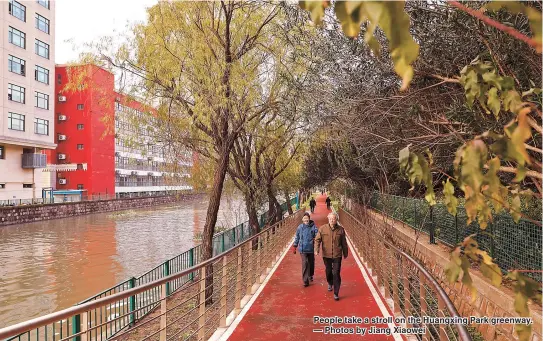  ??  ?? People take a stroll on the Huangxing Park greenway. — Photos by Jiang Xiaowei