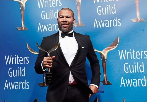  ?? — AP ?? Peele, writer/director of Get Out, poses with his Outstandin­g Original Screenplay award at the 2018 Writers Guild Awards.