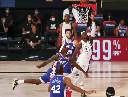  ?? KIM KLEMENT — POOL PHOTO VIA AP ?? Indiana Pacers guard Aaron Holiday (3) shoots next to Philadelph­ia 76ers guard Shake Milton (18) during the second quarter of an NBA