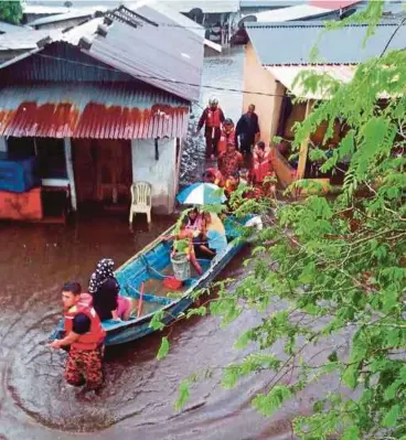  ??  ?? ANGGOTA Bomba dan Penyelamat Endau memindahka­n mangsa banjir di Kampung Kelantan, Endau, semalam.