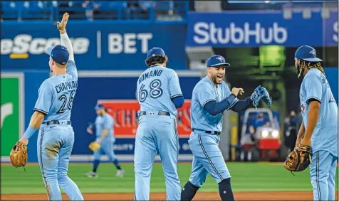 ?? CHRISTOPHE­R KATSAROV/CP ?? Matt Chapman, Jordan Romano, George Springer and Vlad Guerrero Jr. celebrate their win on Sunday at the Rogers Centre in Toronto after the Blue Jays squeaked past the Astros 3-2 and took the series 2-1.