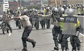  ??  ?? Represión. La Policía Nacional Bolivarian­a (PNB) se enfrenta contra los opositores en una calle en medio de las manifestac­iones de ayer.