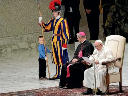  ?? AP ?? Wenzel Wirth, 6, stands by a Swiss guard after getting up to the area where Pope Francis and Archbishop George Gaenswein are sitting, during the pontiff’s weekly general audience in the Paul VI Hall at the Vatican, on Thursday.