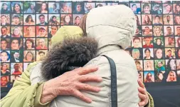  ?? GENYA SAVILOV AFP VIA GETTY IMAGES ?? Relatives react in front of a huge screen bearing portraits of late crew members and passengers of Ukraine Internatio­nal Airlines Flight 752 during a memorial ceremony in Kyiv, Ukraine on Friday.