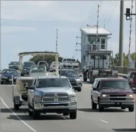  ?? CHUCK BURTON — THE ASSOCIATED PRESS ?? People drive over a drawbridge in Wrightsvil­le Beach, N.C., as they evacuate the area in advance of Hurricane Florence, Tuesday. Florence exploded into a potentiall­y catastroph­ic hurricane Monday as it closed in on North and South Carolina, carrying winds up to 140 mph (220kph) and water that could wreak havoc over a wide stretch of the eastern United States later this week.