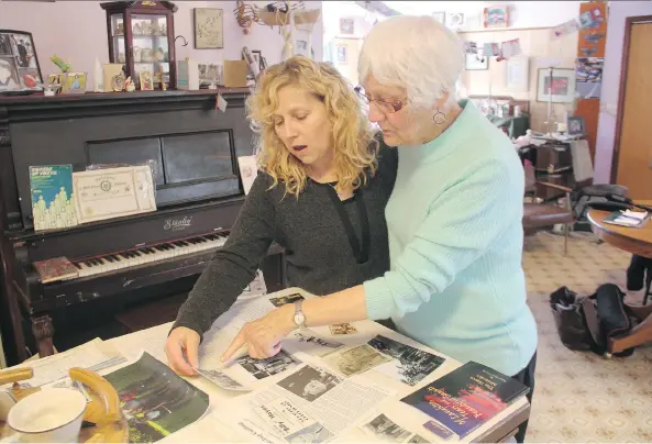  ?? PHOTOS: MORGAN MODJESKI ?? Margaret Joan Looby, right, spends some time with her daughter, Margaret Leepart, examining photos and memorabili­a of Looby’s father, Lt. William Hayes. About 20 of Hayes’ relatives recently toured the battlefiel­d sites where he fought during the Great...