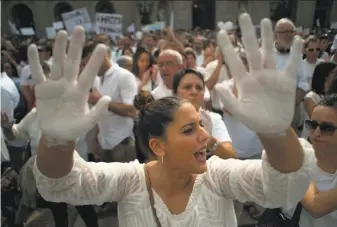  ?? Jorge Guerrero / AFP / Getty Images ?? A demonstrat­or in Barcelona shows her hands painted white during a rally called by the Let’s Talk associatio­n for dialogue. Participan­ts called for negotiatio­ns to defuse the crisis.