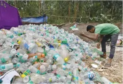  ?? Picture: AFP ?? A waste segregatio­n worker sorts plastic bottles at a dumpsite in Bangalore, India, yesterday.