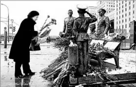  ?? MAXIM SHIPENKOV/EPA ?? A woman places flowers Thursday at a makeshift memorial in Moscow dedicated to the airman who died after a Russian plane was shot down by the Turkish military on Tuesday.