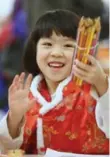  ??  ?? Anna Chen, 4, is happy using pencil crayons to celebrate.