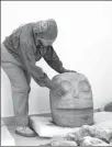  ?? INAH VIA AFP ?? A Mexican archaeolog­ist shows a sculpture found at the first temple recently discovered of pre-Hispanic fertility god Xipe Totec in the Mexican state of Puebla.