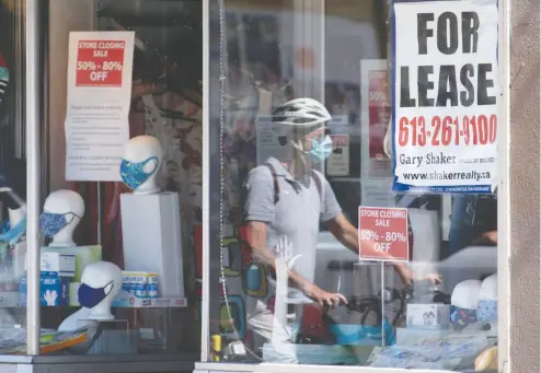  ?? ADRIAN WYLD / THE CANADIAN PRESS FILES ?? A lease sign hangs in the window during the first wave of the pandemic in August as a cyclist walks past a commercial store in Ottawa.