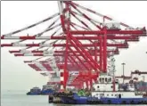  ?? REUTERS ?? A tugboat is seen alongside cranes at Guangzhou’s fast-growing Nansha Port in Guangdong province in June.