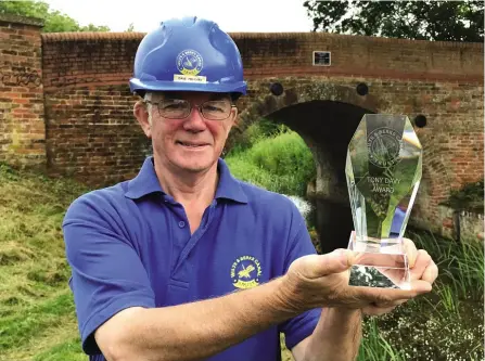  ?? PHOTO: JUSTIN GUY ?? Canal Trust branch chairman Dave Maloney with the Tony Davy Award, at Double Bridge near Lacock.