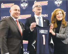  ?? Stephen Dunn / Associated Press ?? Dan Hurley holds a jersey as he is flanked by UConn athletic director David Benedict, left, and school president Susan Herbst during a news conference introducin­g him as the new men’s basketball coach March 23.