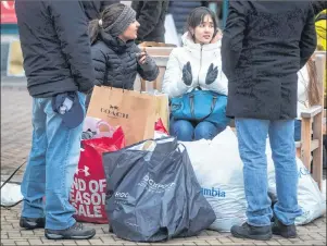  ?? CP PHOTO ?? People sit with bags of Boxing Day sale purchases at the McArthur Glen Designer Outlet mall, in Richmond, B.C., on Dec. 26, 2017.