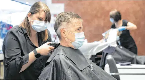  ?? FOTO: PETER KLAUNZER/DPA ?? Mundschutz ist Pflicht: Ab Montag, wenn die Friseursal­ons wieder öffnen, gelten umfassende Maßnahmen für den Infektions­schutz.