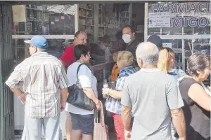  ??  ?? En una farmacia del Mercado 4 solo se permite entrar a cuatro personas a la vez, para evitar aglomeraci­ón, pero las personas esperan afuera sin guardar distancia.