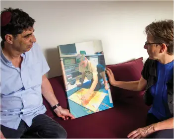  ??  ?? SIMHA AND LEAH Goldin with a photo of Hadar doing one of the activities he loved – painting. This is his last piece before he was killed.