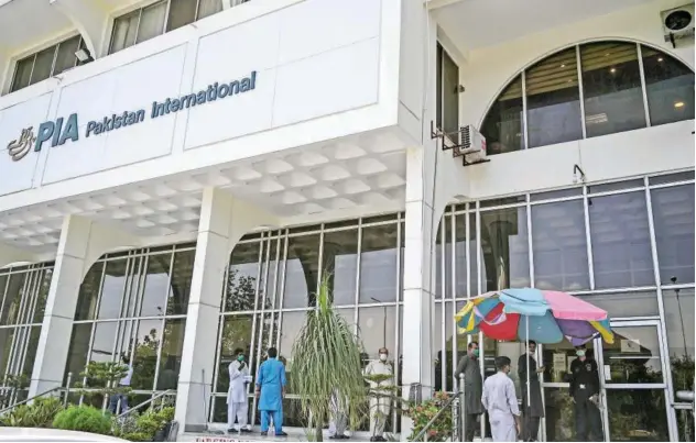  ?? File/agence France-presse ?? ↑
Visitors stand outside the office of Pakistan Internatio­nal Airlines in Islamabad.