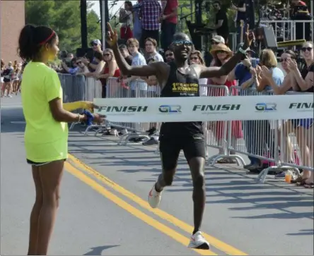  ?? STAN HUDY - THE SARATOGIAN ?? Kenyan runner Eliud Ngetich is all smiles as he looks to break the tape with a new course record, 18 minutes, 59.3 seconds Thursday at the Firecracke­r 4 4-mile road race in Saratoga Springs.