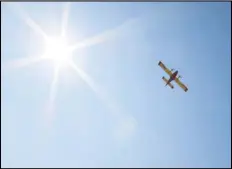  ?? JULIE DRAKE/VALLEY PRESS ?? A CL-415 Super Scooper fire-fighting aircraft flies over the Antelope Valley Press office in Palmdale on its way to Palmdale Lake to pick up a load of water that will be dumped on the Bobcat Fire. Los Angeles County is leasing two of the aircraft from the Government of Quebec.