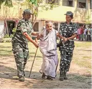  ?? PTI ?? Of service: Security personnel assist an elderly voter at a polling station in Balurghat in Dakshin Dinajpur district of West Bengal on Friday.