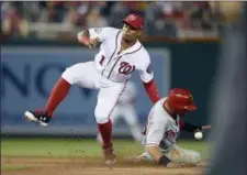  ?? NICK WASS — THE ASSOCIATED PRESS ?? The Phillies’ Cesar Hernandez, right, steals second during the fifth inning against Nationals shortstop Wilmer Difo, Sunday, in Washington.