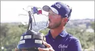  ?? Michael Thomas / Associated Press ?? Andrew Landry kisses the Valero Texas Open championsh­ip trophy on Sunday in San Antonio. Landry won with a score of 17 under par.