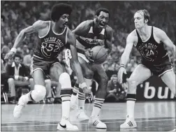  ?? AP FILE PHOTO ?? The Warriors’ George Johnson, left, and Rick Barry double-team Washington Bullets star Elvin Hayes during Game 1 of the NBA Finals on May 18, 1975. The Warriors rallied from a 16-point deficit to win 101-95 on their way to an improbable sweep.