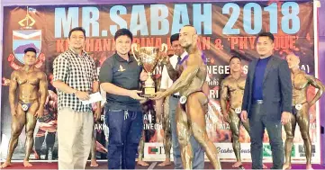  ??  ?? NEW MR SABAH: Remy (right) receiving his Champion of Champions trophy from UTC Sabah Gen Y Centre manager Mas Syazwan Masood.