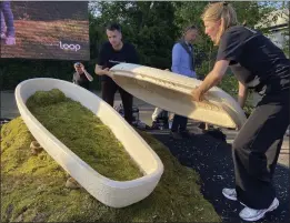  ?? ALEKSANDAR FURTULA — THE ASSOCIATED PRESS ?? Director Lonneke Westhoff, right, and founder Bob Hendrikx, left, of Dutch startup Loop Biotech display one of the cocoon-like coffins, grown from local mushrooms and upcycled hemp fibres, designed to dissolve into the environmen­t amid growing demand for more sustainabl­e burial practices, Monday in Delft, Netherland­s.